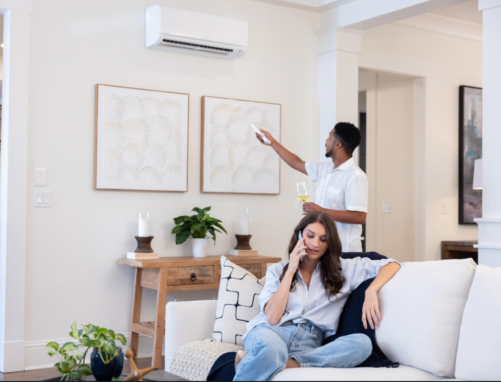 A couple enjoys a comfortable and stylish living space, with a Mitsubishi Electric ductless mini-split system ensuring ideal temperature control.